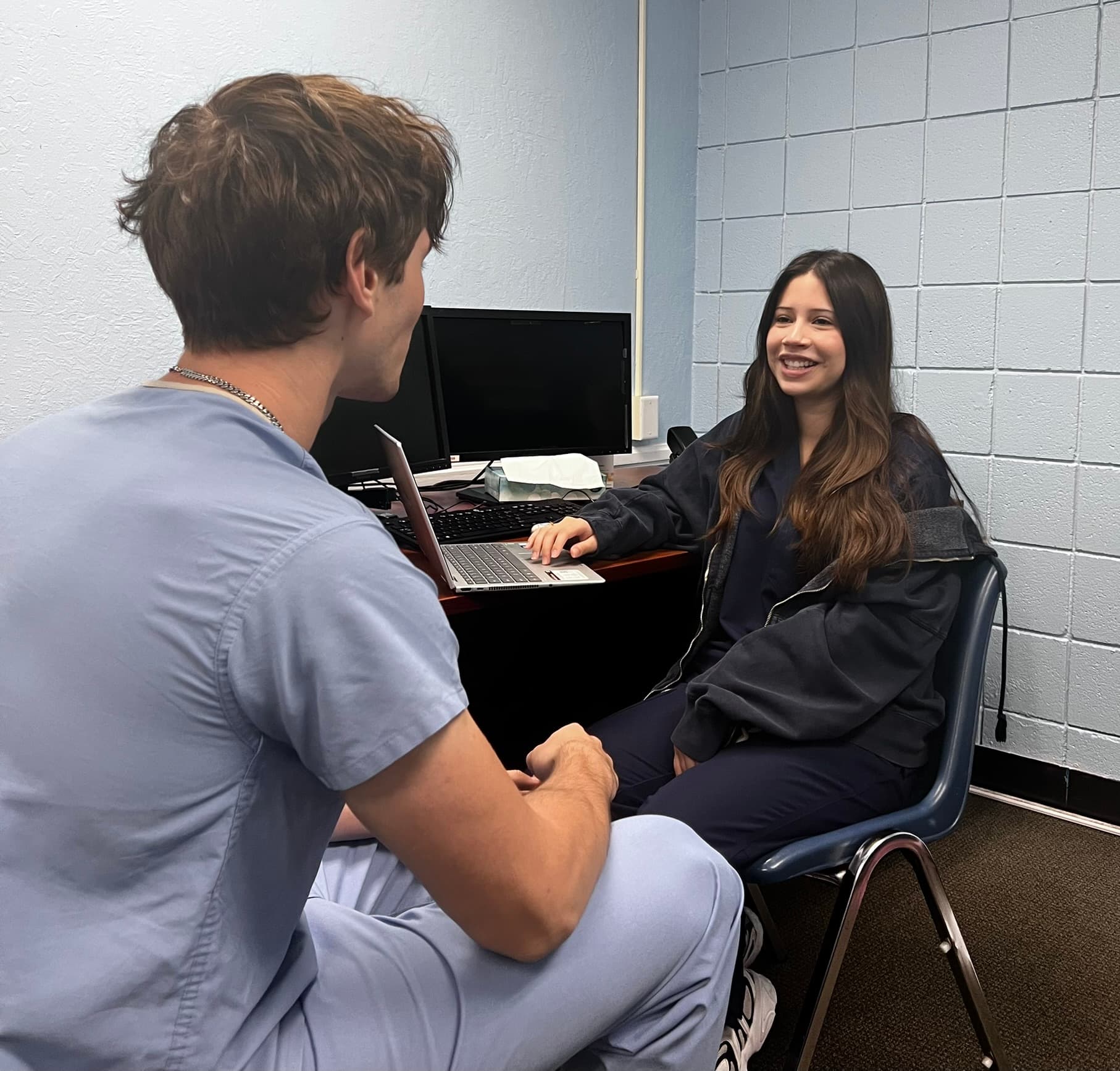 Two clinic team members talking at a workstation inside the clinic