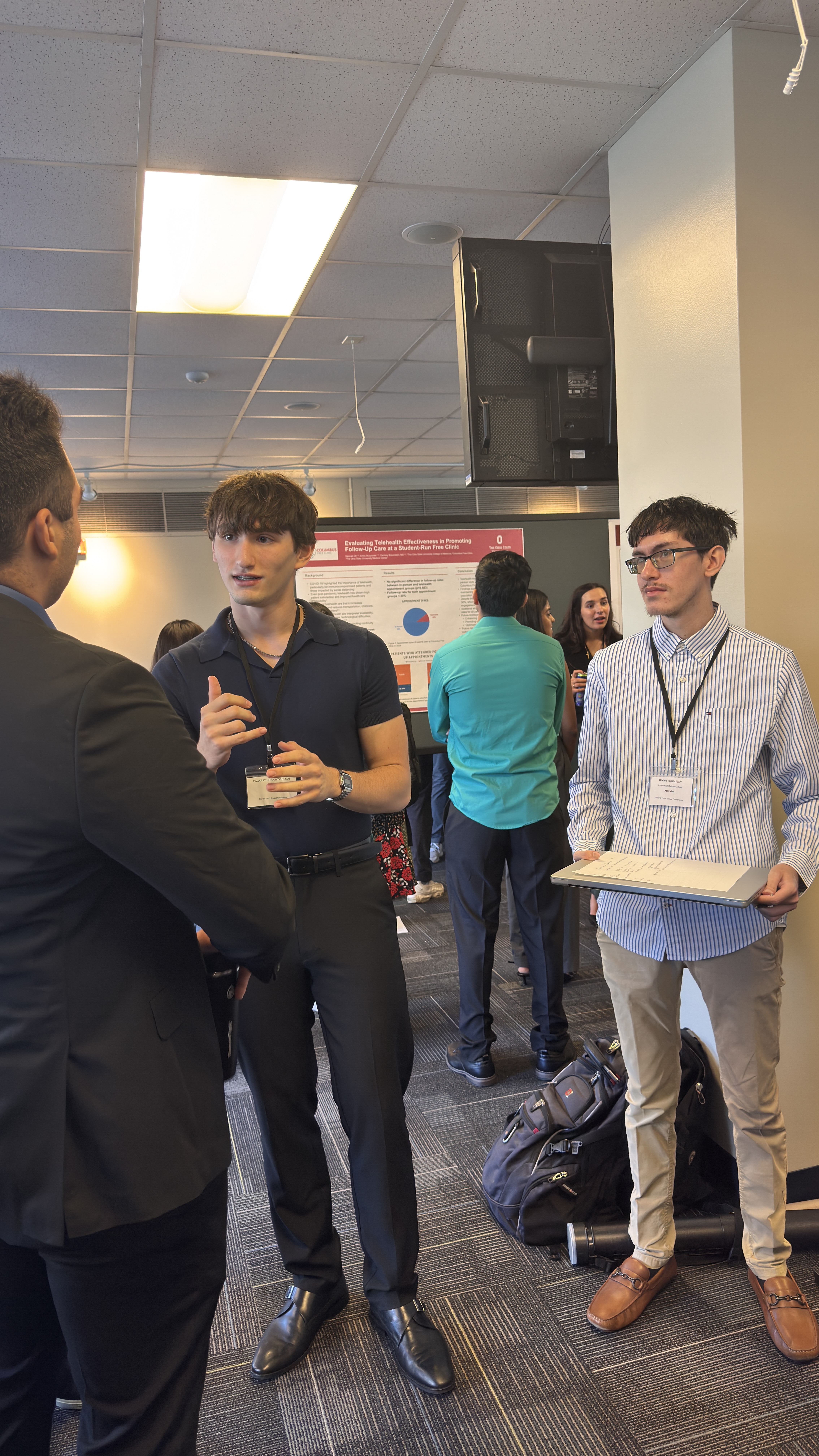 Pagkratios explaining the CIVIC platform to a conference attendee, with Riyan holding a laptop beside him